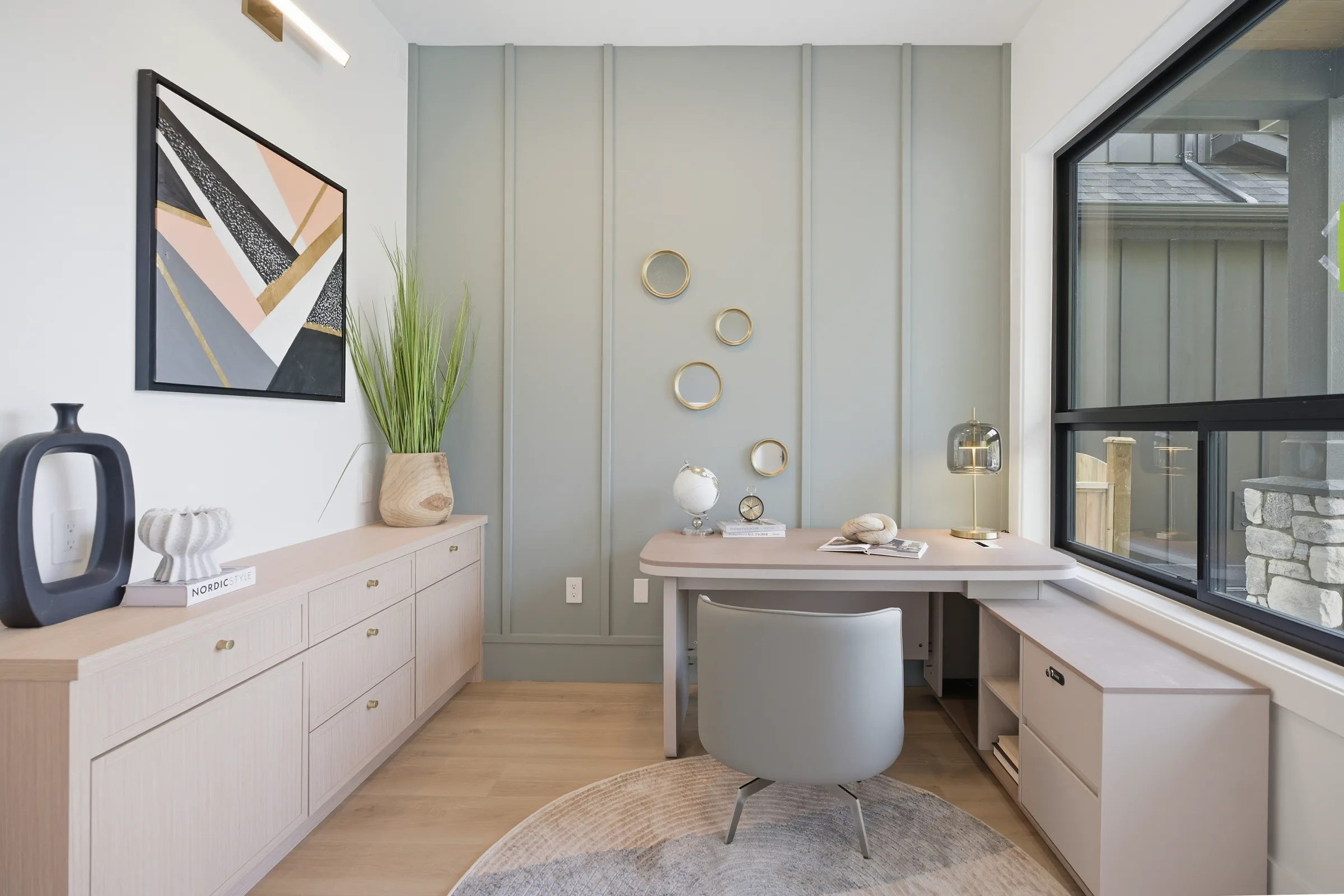 Styled home office with a black-framed corner window, composed as architecture rather than as a listing.
